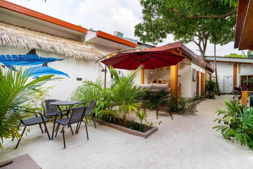 Outdoor seating area with parasol and plants at Tropico Villa, Ukulhas